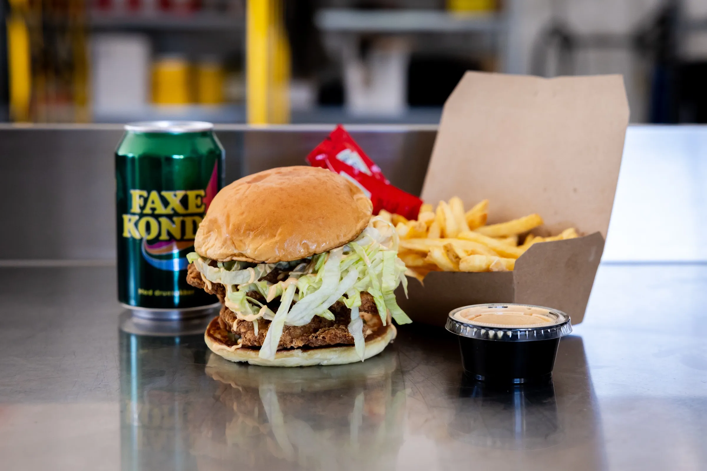 Fried Chicken Sandwich med salat, fries, dip og en Faxe Kondi